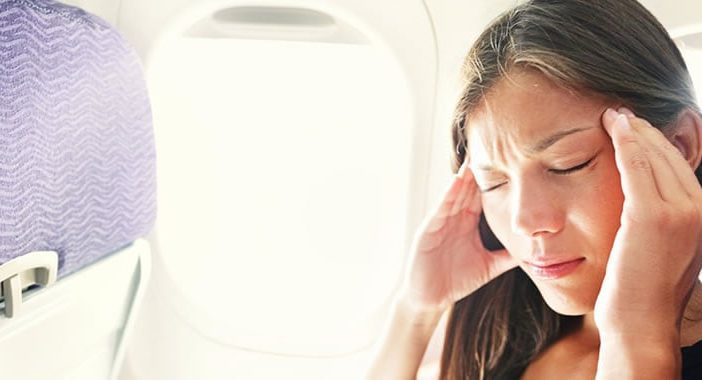 woman with travel pain on an airplane